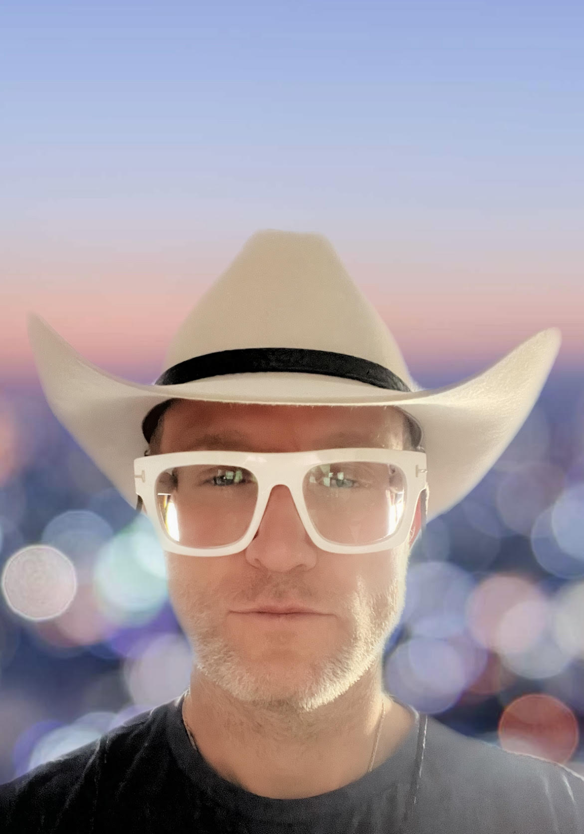 Thoryn Stephens at dusk in a pale hat and glasses